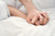 couples hold hands during sex on white bedsheets
