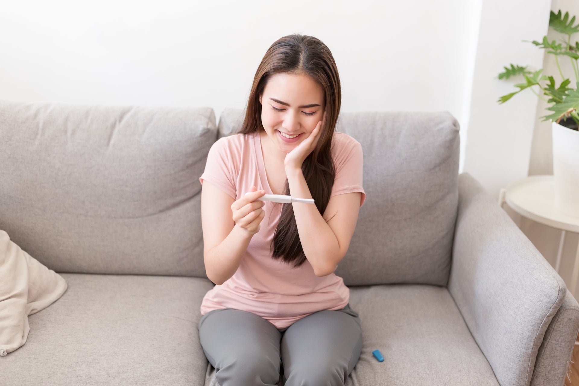 Asian woman happy about her pregnancy test result