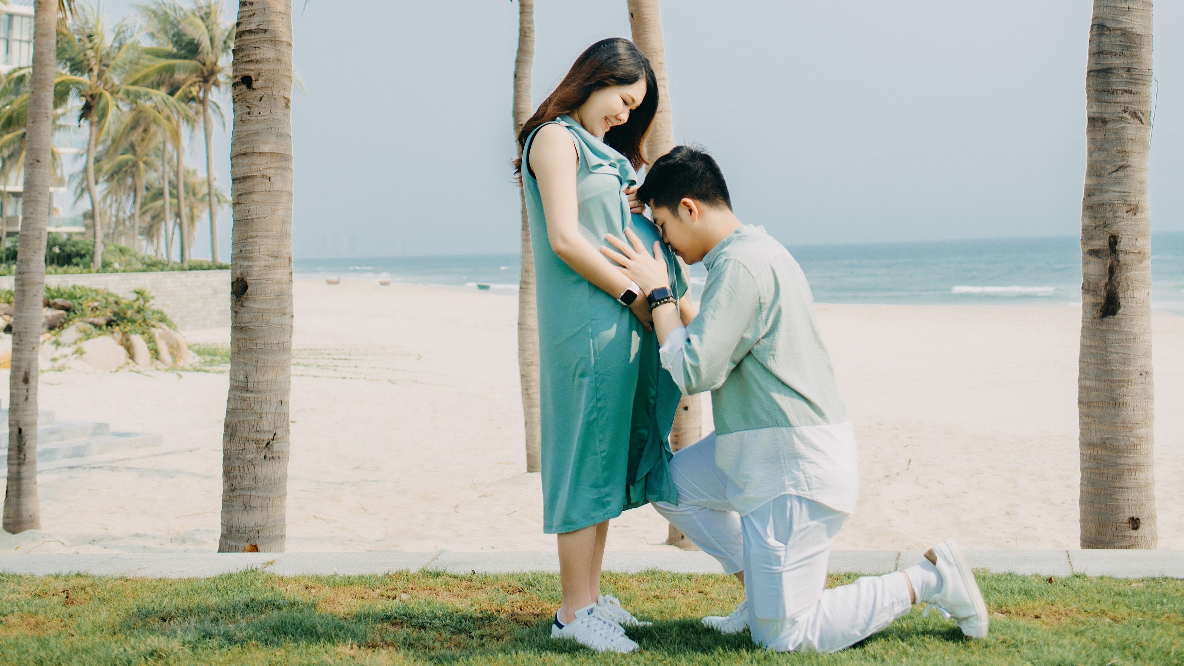 husband nuzzles wife's baby bump