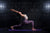 a woman in a yoga pose on a purple exercise mat