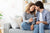 couple embraces lovingly and happily on couch while woman holds pregnancy test